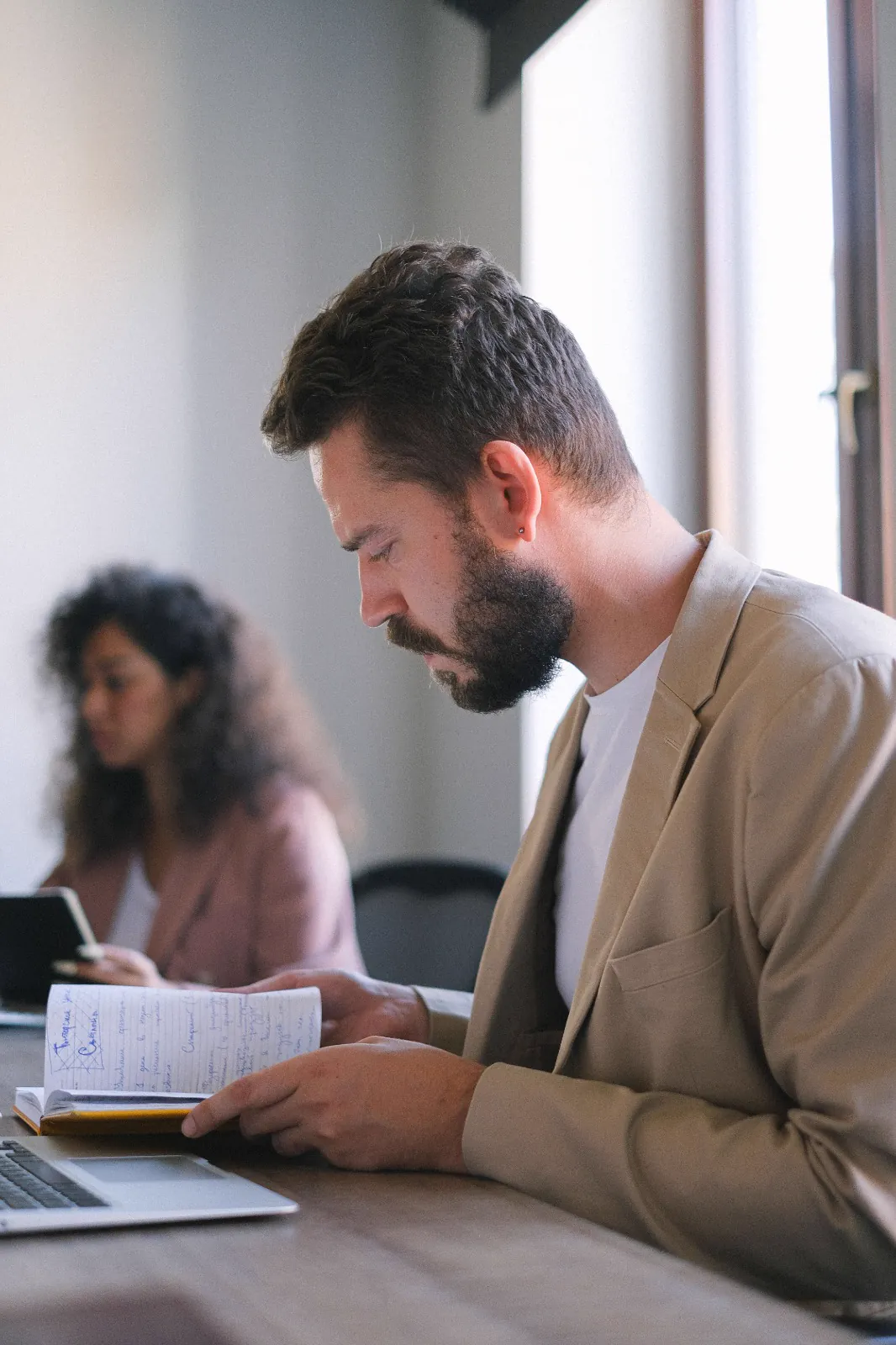 Persona repasando sus apuntes en un cuaderno, en una mesa de trabajo